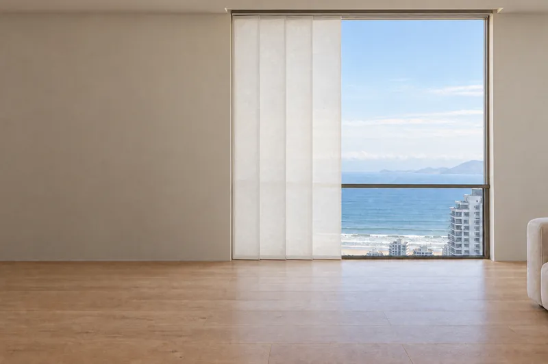 A mesma janela para o mar com cortina painel com as folhas recolhidas à esquerda.