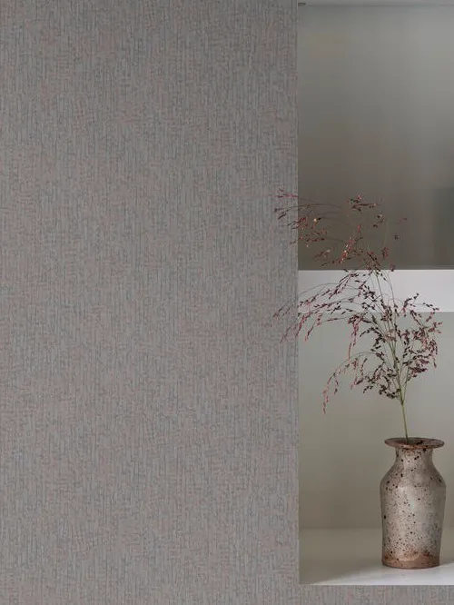 Papel de parede cinza texturizado ao lado de um nicho branco com vaso de cerâmica e flores secas.