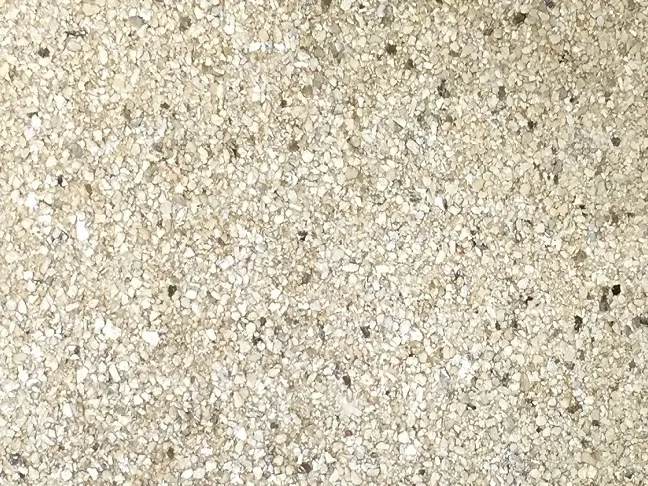 Textura de papel de parede Mica, com fragmentos minerais em bege e dourado.