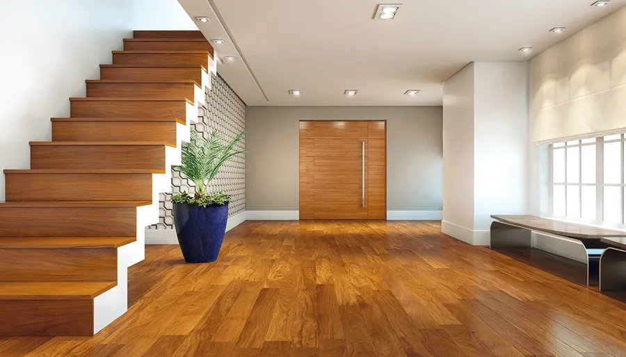 Hall com escada de madeira, vaso azul e piso amadeirado em tom mel.