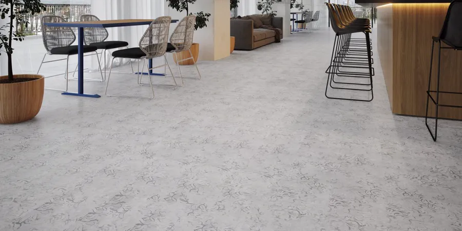 Espaço comercial com mesas, banquetas e piso laminado cinza-claro com estampa sutil.