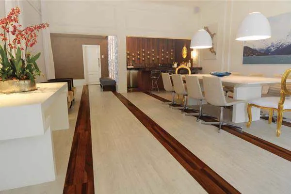 Sala de jantar clara com piso em tom areia e faixas de madeira escura.