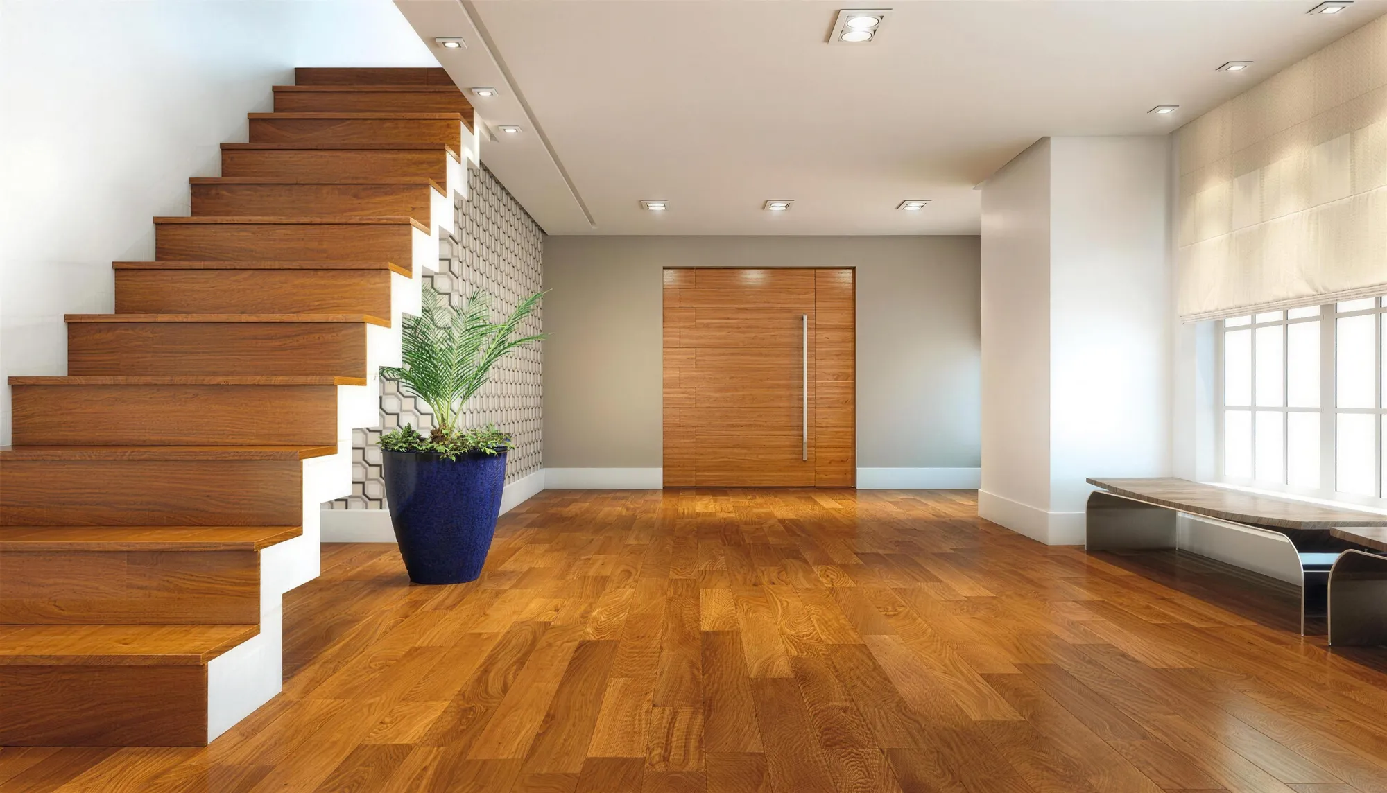 Hall com escada de madeira, vaso azul e piso amadeirado em tom mel.